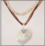 A beaded opalescent necklace having a yellow metal spring clasp along with a carved opalescent stone