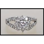 A hallmarked 950 platinum and diamond Art Deco style ring. The central round brilliant cut diamond