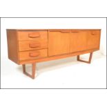 A retro 20th Century teak wood sideboard credenza having a configuration of cupboards and drawers
