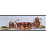 A collection of copper and brass wares dating from the 19th Century to include a large preserve pan,