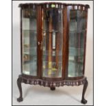 A 20th Century mahogany glazed corner display cabinet, the serpentine fronted cabinet having a