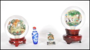 Two 20th Century Chinese paperweight glass spheres having reverse painted scenes to the inside one
