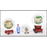 Two 20th Century Chinese paperweight glass spheres having reverse painted scenes to the inside one