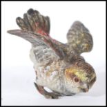 An early 20th Century Austrian cold cast figurine of a bird, modelled leant forward with spread
