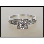 A 14ct white gold and diamond Art Deco style ring. The ring with central brilliant cut diamond