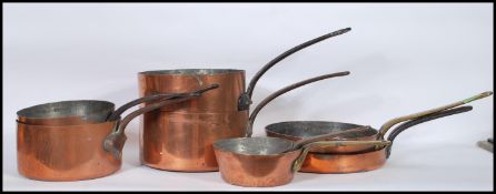 A collection of 19th and 20th Century graduating copper saucepans and skillet pans, stamped WES to