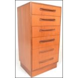 A retro 20th Century circa 1970's G-Plan teak wood Kelso chest of six drawers being raised on an