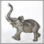 A large believed early 20th century bronze figural scuplture of an African Elephant with raised