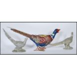 A pair of silvered composite models of Pheasants together with a larger multi coloured Pheasant