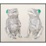 A pair of unusual salt and pepper condiments in the form of frogs having marcasite adorned eyes.