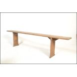 A 19th century French refectory pig bench. The bench with a shaped single plank top of pine
