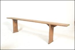 A 19th century French refectory pig bench. The bench with a shaped single plank top of pine