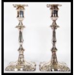 A pair of late 19th century silver candlesticks of rococo form being cast in relief and filled. Each