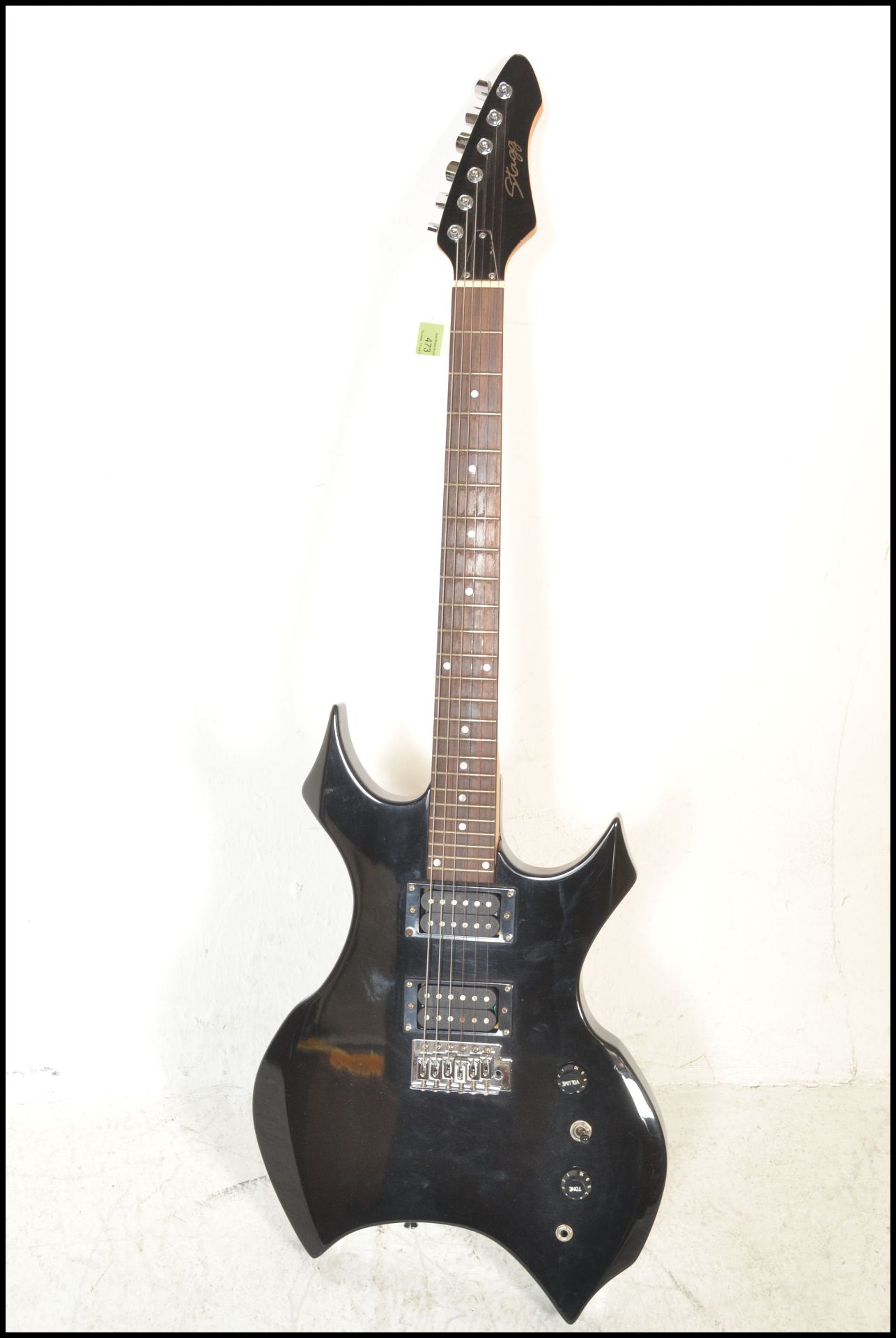 A heavy metal style six string electric guitar made by Stagg, finished in black having having chrome