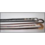 A collection of four walking stick canes to includ