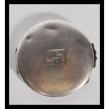 A silver hallmarked lroundel shaped ladies powder compact with inset mirror to the lid, powder