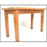 A vintage early 20th century chunky country pine scrub top dining table being raised on squared legs