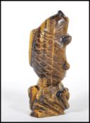 A 20th Century Chinese carved tigers eye ornament in the form of a koi carp fish jumping from the