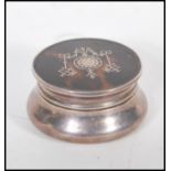 An early 20th Century William Comyns & Sons Ltd silver pill box of round form having a tortoise