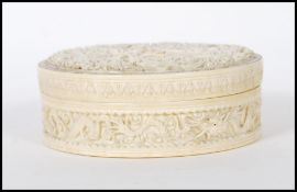 A late 19th Century Chinese carved ivory circular box and cover being carved with three dragons with