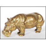 A 20th Century cast brass figurine in the form of a hippo stood on all four feet with it's mouth