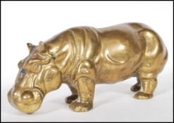 A 20th Century cast brass figurine in the form of a hippo stood on all four feet with it's mouth