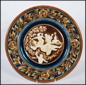 An Austrian 19th century porcelain wall charger having brown glaze with white cameo in relief centre