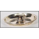 A silver early 20th Century cigar ashtray, the circular tray with central cigar support / rest,
