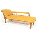 A late Victorian oak chaise longue day bed being raised on turned legs with yellow velour upholstery
