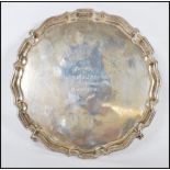 A silver hallmarked calling card dish, the scalloped gallery dish raised on four scroll feet with