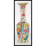 A 19th century Chinese miniature famille rose vase of baluster form being handpainted with scenes of