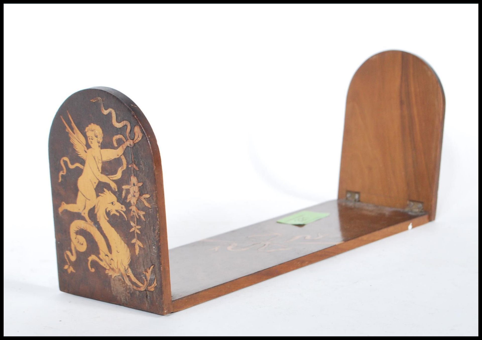 A Sorrento marquetry book slide / stand having two curved folding leaves with inlaid cherub and