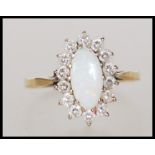 A hallmarked 9ct gold ring set with an oval cut opal with a halo of white stones. Marked with import