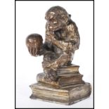 A Darwinian style cast metal novelty table cigarette / cigar lighter, in the form of a seated monkey