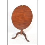 A 19th century George III mahogany tilt top occasional / dining table. Raised on tripod splayed
