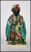 An unusual 18th century / 19th century Staffordshire figurine of a moor. The blackamoor turban