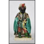 An unusual 18th century / 19th century Staffordshire figurine of a moor. The blackamoor turban