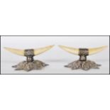 A pair of silver hallmarked and bon knife rests, the bone carved in the form of horns raised on