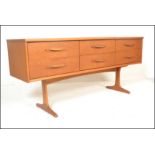 A retro 20th Century teak wood sideboard credenza having a configuration of six drawers raised on