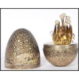 A silver hallmarked Stuart Devlin ' surprise egg ' having a textured exterior opening to reveal a