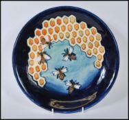 A Moorcroft Honeycomb pattern plate having blue ground with tubelined honeycomb and bee