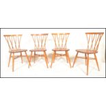 A set of four mid 20th century Ercol Windsor Candlestick back dining chairs in light elm and beech