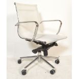 A retro desk swivel arm chair in the manner of Charles and Ray Eames being raised on chromed