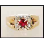 A stamped 14ct gold ring claw set with a round cut synthetic ruby. Size S. Weight 6.3g.