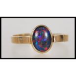 A stamped 375 9ct gold ring set with an opalescent cabochon. Weight 1.7g. Size N.