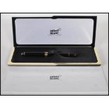 A Mont Blanc Meisterstuck fountain pen, being black with gilt details and having a 14ct gold nib