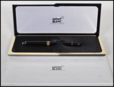 A Mont Blanc Meisterstuck fountain pen, being black with gilt details and having a 14ct gold nib
