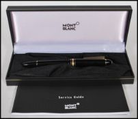 A Mont Blanc Meisterstuck fountain pen in a black colourway with gilt details having a 14ct gold