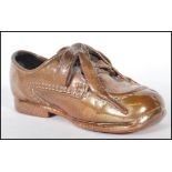A 20th Century bronzed child's Clarks shoe. The childs original Clarks leather shoe being coated