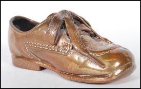 A 20th Century bronzed child's Clarks shoe. The childs original Clarks leather shoe being coated